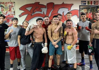 Young boxing athletes posing in front of a graffiti mural